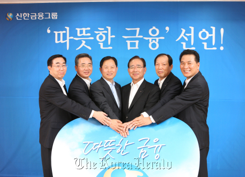 Shinhan Financial Group chairman Han Dong-woo (fourth from left) poses with business unit chiefs, including bank CEO Suh Jin-won (third from left), after unveiling the group’s business policy toward warm-hearted services.  Shinhan Financial