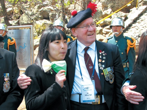 British veteran William Hall laughs with a student who will benefit from the scholarships given out by Korean War veterans on their visit to the Gloster Monument on Thursday. (Kirsty Taylor/The Korea Herald)