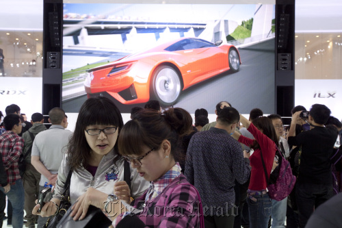 People attend the auto show in Beijing on Friday.  Bloomberg