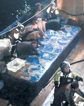 Officers of the Korea Coast Guard arrest Chinese fishermen who attacked and injured four local officials in the West Sea in the early hours of Monday. (Korea Coast Guard)