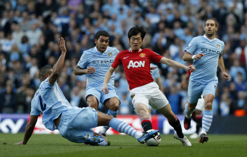 <YONHAP PHOTO-0396> Manchester City's Vincent Kompany, left, competes for the ball with Manchester United's Park Ji-Sung, third left, watched by Carlos Tevez, second left, and Pablo Zabaleta, right, during the English Premier League soccer match between Manchester City and Manchester United at the Etihad Stadium in Manchester, Monday, April 30, 2012. (AP Photo/Matt Dunham) /2012-05-01 07:30:36/ <저작권자 ⓒ 1980-2012 ㈜연합뉴스. 무단 전재 재배포 금지.>
Manchester City’s Vincent Kompany (left) and Manchester United’s Park Ji-sung challenge for the ball.  AP-Yonhap News