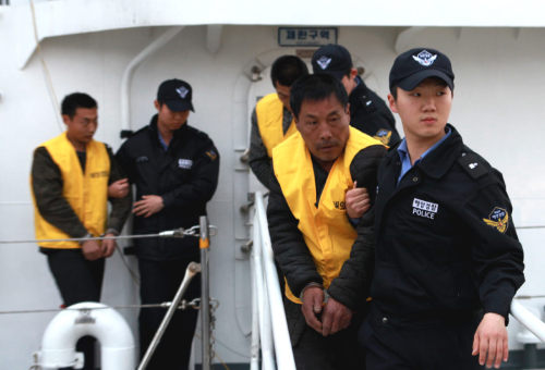 Coast Guard officers haul in Chinese sailors on Monday after they attacked and injured Korean officers.   Yonhap News
