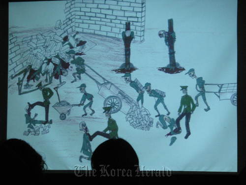 Participants in the North Korean Human Rights Speaker Series view artist renderings of a prison camp in the North on Wednesday night at the Artreon Toz in Sinchon.  Rob York/The Korea Herald