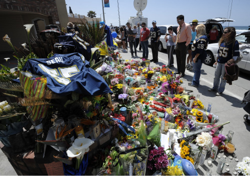 <YONHAP PHOTO-0071> A San Diego Chargers #55 jersey sits in the foreground as fans look over a memorial in driveway of former NFL star Junior Seau's house, Thursday, May 3, 2012, in Oceanside, Calif. Seau's death in Oceanside, in northern San Diego County, stunned the region he represented with almost reckless abandon. (AP Photo/Denis Poroy)/2012-05-04 05:17:40/ <저작권자 ⓒ 1980-2012 ㈜연합뉴스. 무단 전재 재배포 금지.>
Fans look at a memorial for former NFL star Junior Seau in Oceanside, California, Thursday.  AP-Yonhap News