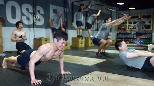 Crossfitters power through their grueling workout at a CrossFit gym in Seoul. 		 Kim Myung-sub/The Korea Herald