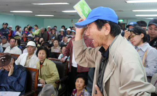 <YONHAP PHOTO-0729> 성토하는 저축은행 예금자 (제주=연합뉴스) 고성식 기자 = 미래저축은행이 금융당국으로부터 영업정지 처분을 받은 가운데 7일 오전 제주시 이도2동 제주본점에서 열린 설명회에서 한 예금자가 통장을 들고 나와 성토하고 있다. 2012.5.7 koss@yna.co.kr/2012-05-07 14:46:09/ <저작권자 ⓒ 1980-2012 ㈜연합뉴스. 무단 전재 재배포 금지.>
A client protests the suspension of business at a Mirae Savings Bank branch on Jeju Island on Monday.   Yonhap News