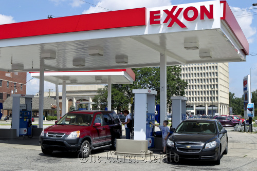 A customer fills up her car with fuel at an Exxon Mobil Corp. gas station in Dearborn, Michigan.  Bloomberg
A customer fills up her car with fuel at an Exxon Mobil Corp. gas station in Dearborn, Michigan.  Bloomberg