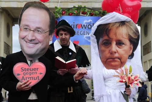 <YONHAP PHOTO-1170> Activists wear masks featuring German chancellor Angela Merkel (R) and incoming French socialist president Francois Hollande (L) as they perform a fake marriage in front of the Brandenburg Gate in Berlin, on May 7, 2012. Non governmental organisations such as Oxfam and Attac organised the action to call for an introduction of a financial transaction tax in Europe one day after the second round of French Presidential election. AFP PHOTO / JOHN MACDOUGALL../2012-05-07 20:17:03/ <저작권자 ⓒ 1980-2012 ㈜연합뉴스. 무단 전재 재배포 금지.>
Activists wear masks featuring German chancellor Angela Merkel (right) and incoming French socialist president Francois Hollande as they perform a fake marriage in front of the Brandenburg Gate in Berlin on Monday.  AFP-Yonhap News
Activists wear masks featuring German chancellor Angela Merkel (right) and incoming French socialist president Francois Hollande as they perform a fake marriage in front of the Brandenburg Gate in Berlin on Monday.  AFP-Yonhap News