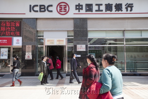 Pedestrians walk past a branch of the Industrial and Commercial Bank of China Ltd. in Beijing. Bloomberg