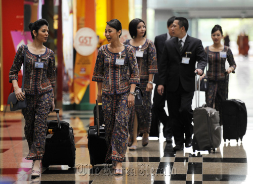 Singapore Airlines Ltd. flight staff walk through Changi Airport in Singapore.  Bloomberg