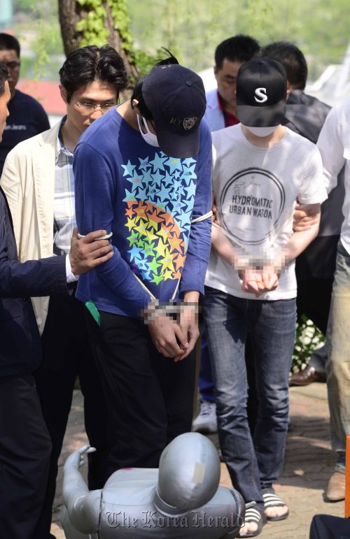 지난 달 30일 서울 서대문구 창천근린공원에서 대학생 김모(20)씨를 칼로 40차례 이상 난자해 죽인 '신촌 대학생 살인사건'의 범인인 이모(16)군과 윤모(18)군이 8일 오전 사건현장에서 현장검증을 하고 있다. 박해묵 기자/mook@heraldm.com
Two teenage suspects in last month’s stabbing of a college student reenact the crime in a park in central Seoul on Tuesday.
Park Hae-mook/The Korea Herald