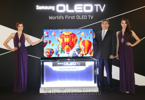 Kim Hyun-suk (Second from right), executive vice president of the visual display business at Samsung Electronics, introduces the firm’s 55-inch OLED TV at a showcase in southern Seoul on Thursday. Samsung Electronics