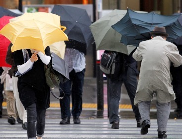 Japanese people cross a street in Tokyo on Thursday. (AP-Yonhap News)