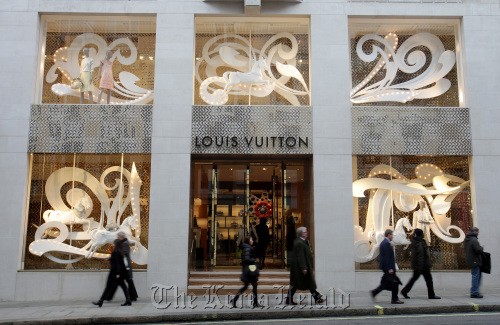 Pedestrians pass the Louis Vuitton store on New Bond Street in London.  Bloomberg
