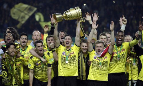 <YONHAP PHOTO-0375> Dortmund's Robert Lewandowski of Poland, center, lifts the trophy after his team won the German soccer cup final between Borussia Dortmund and FC Bayern Munich at the Olympic stadium in Berlin, Saturday, May 12, 2012. (AP Photo/Gero Breloer) - NO MOBILE USE UNTIL 2 HOURS AFTER THE MATCH, WEBSITE USERS ARE OBLIGED TO COMPLY WITH DFB-RESTRICTIONS, SEE INSTRUCTIONS FOR DETAILS ?/2012-05-13 06:26:28/ <저작권자 ⓒ 1980-2012 ㈜연합뉴스. 무단 전재 재배포 금지.>
Dortmund players celebrate with their trophy on Saturday.  AP-Yonhap News