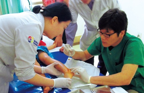 Korean medical workers treat a wounded child in the Lao National Children’s Hospital in Vientiane. (KOICA)