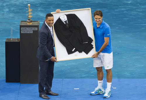 <YONHAP PHOTO-0372> Roger Federer from Switzerland, right, receives a black suit from U.S. actor Will Smith's last movie 'Men in Black 3' after he won the final match against Tomas Berdych from the Czech Republic in the Madrid Open tennis tournament in Madrid, Sunday, May 13, 2012. (AP Photo/Daniel Ochoa de Olza)/2012-05-14 07:01:30/ <저작권자 ⓒ 1980-2012 ㈜연합뉴스. 무단 전재 재배포 금지.>
Roger Federer (right) receives a suit from actor Will Smith’s latest movie “Men in Black 3” after winning the Madrid Open.  AP-Yonhap News