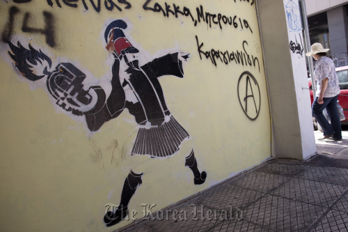 Graffiti depicting the Euro symbol as a grenade about to be thrown by a soldier sits on a wall in Athens.  Bloomberg