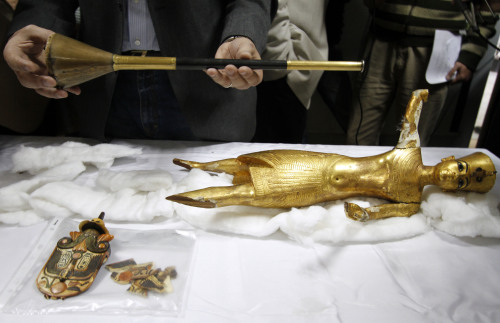 <YONHAP PHOTO-0031> FILE - In this Tuesday, April 12, 2011 file photo, a wooden statue of Tutankhamun, right, the gilded bronze and wooden trumpet of Tutankhamun and a part of Tutankhamun's fan, left, three of four objects that were missing and returned, are displayed during a news conference in the office of Egypt's Minister of State for Antiquities Zahi Hawass, in Cairo. Taking advantage of Egypt's political upheaval, thieves have gone on a treasure hunt with a spree of illegal digging, preying on the country's ancient pharaonic heritage. (AP Photo/Khalil Hamra, File)/2012-05-13 00:46:01/ <저작권자 ⓒ 1980-2012 ㈜연합뉴스. 무단 전재 재배포 금지.>
In this April 12 file photo, a wooden statue of Tutankhamun (right), the gilded bronze and wooden trumpet of Tutankhamun and a part of the boy-king’s fan (left), three of four objects that were missing and returned, are displayed during a news conference in the office of Egypt’s Minister of State for Antiquities Zahi Hawass, in Cairo.    AP-Yonhap News