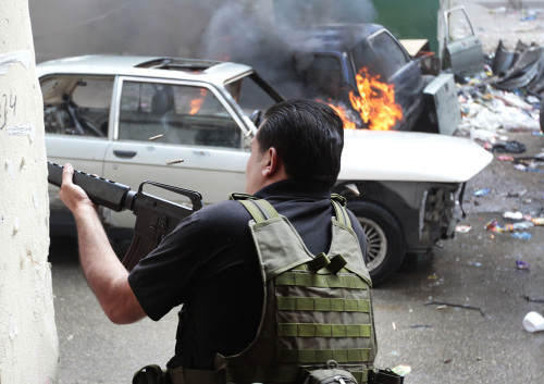 <YONHAP PHOTO-0015> A Sunni gunman fires in a front of burned car during a clashes, in the northern port city of Tripoli, Lebanon, Sunday May 13, 2012. Sectarian violence linked to the unrest in neighboring Syria shook the northern Lebanese city of Tripoli on Sunday, with street clashes killing one soldier and two civilians, the state news agency said. Residents said running gunbattles broke out in the city Saturday and continued through the night primarily between a neighborhood populated by Sunni Muslims opposed to Syrian President Bashar Assad and another area with many Assad backers from his Alawite sect. (AP Photo/Hussein Malla)/2012-05-14 00:12:46/ <저작권자 ⓒ 1980-2012 ㈜연합뉴스. 무단 전재 재배포 금지.>
A Sunni gunman fires in a front of burned car during clashes, in the northern port city of Tripoli, Lebanon, Sunday.  AP-Yonhap News
A Sunni gunman fires in a front of burned car during clashes, in the northern port city of Tripoli, Lebanon, Sunday.  AP-Yonhap News