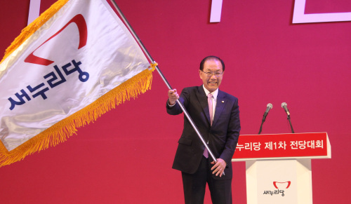 <YONHAP PHOTO-1317> 당기 흔드는 황우여 대표 (고양=연합뉴스) 백승렬 기자 = 새누리당 황우여 새 대표가 15일 고양시 킨텍스에서 열린 제1차 전당대회에서 박근혜 비대위원장으로부터 당기를 전달받아 흔들고 있다. 2012. 5. 15 srbaek@yna.co.kr/2012-05-15 18:59:32/ <저작권자 ⓒ 1980-2012 ㈜연합뉴스. 무단 전재 재배포 금지.>
Hwang Woo-yea waves the Saenuri Party flag after winning the leadership election on Tuesday.  Yonhap News