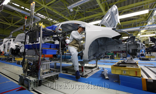 A worker assembles a Toyota Motor Corp. Corolla Axio sedan on the production line of the Central Motor Corp. plant in Ohira village, Miyagi Prefecture, Japan.  Bloomberg