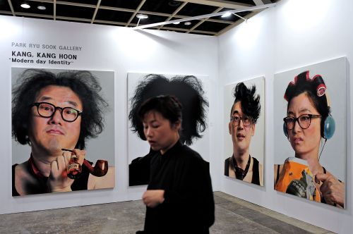 <YONHAP PHOTO-1068> A waitress walks past artworks displayed at Asia's premier art fair "Art HK" in Hong Kong on May 16, 2012. The four-day event now in its fifth edition opens on May 17, bringing artists, collectors and dealers from around the world to a city whose booming market illustrates a shift in wealth from West to East. AFP PHOTO / Philippe Lopez../2012-05-16 18:00:08/ <저작권자 ⓒ 1980-2012 ㈜연합뉴스. 무단 전재 재배포 금지.>
A waitress walks past artworks displayed at Asia’s premier art fair Art HK in Hong Kong on Wednesday.  AFP-Yonhap News