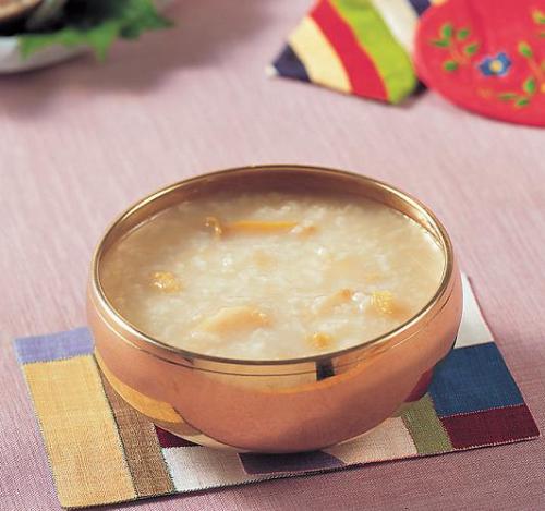 Jeonbokjuk, Korean abalone rice porridge in a bowl, garnished with chopped abalone and sesame