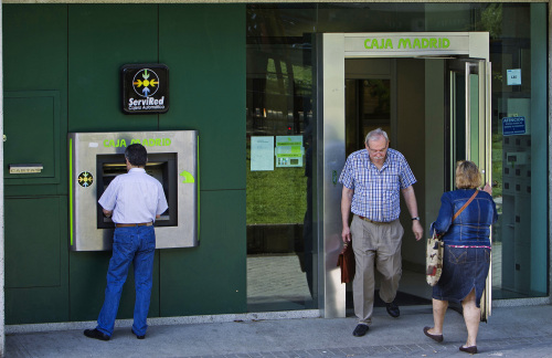 <YONHAP PHOTO-0247> A customer uses an automated teller machine (ATM) outside a Caja Madrid bank branch in Madrid, Spain, on Friday, May 18, 2012. Banco Santander SA and Banco Bilbao Vizcaya Argentaria SA, Spain's biggest lenders, were cut three levels by Moody's Investors Service, which cited a recession and mounting loan losses in downgrading 16 of the nation's banks. Photographer: Angel Navarrete/Bloomberg/2012-05-19 08:34:01/ <저작권자 ⓒ 1980-2012 ㈜연합뉴스. 무단 전재 재배포 금지.>
A customer uses an automated teller machine outside a Caja Madrid bank branch in Madrid on Friday.     Bloomberg