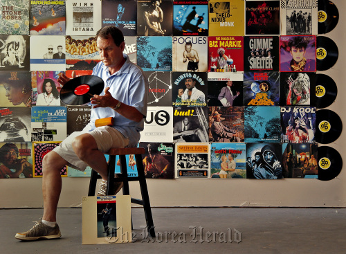 Sean Kayes of Radio-Active Records inspects a disc inside the record store in Fort Lauderdale, Florida.    Miami Herald/MCT