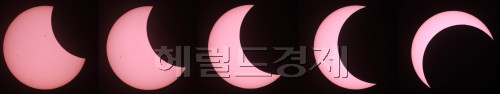 부분일식이 이뤄진 21일 오전 서울 중구에서 바라본 태양이 달에 가려지고 있다.<오전 6시 40분 부터 최대로 가려지는 7시 32분까지 순차적으로 촬영했다.<br />김명섭 기자 msiron@
진짜 해를 품은 달, ‘해품달’이다. 해가 달에 가려졌다. 부분일식은 21일 오전 6시16분부터 8시41분까지 2시간25분가량 진행됐다. 직장인들은 태양의 80%까지 가려진 부분일식을 보기 위해 바쁜 출근길을 멈춰선 채 셀로판지로 눈을 가리고 해품달을 지켜봤다. 20%의 해가 이렇게 중요할 줄이야. 다음 일식은 4년 후인 2016년 3월 9일이다. 일식은 부분일식, 개기일식, 금환일식으로 나뉜다. 부분일식은 해의 일부, 개기일식은 해의 전부가 가려지고, 금환일식은 해의 테두리만 남아 금(金)반지처럼 보인다. 　김명섭 기자/msiron@heraldm.com
