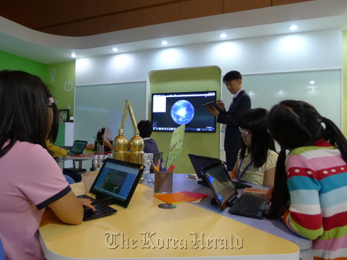 Students use digital textbooks during the “Smart Class” exhibition at the APEC Education Ministerial Meeting on Monday.  Oh Kyu-wook/The Korea Herald