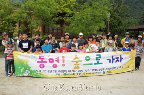 Volunteer workers from Cardif in Korea and children from the Dong-myung Child Welfare Center pose before attending a forest exploration program on Saturday.     Cardif in Korea