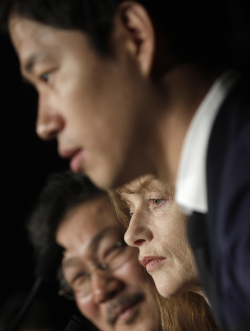Director Hong Sangsoo (left), actors Isabelle Huppert(center) and Yu Junsang listen during a press conference at the 65th international film festival on Monday. (AP-Yonhap News)