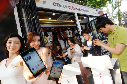 LG전자가 한 달간 ‘옵티머스 이동체험관’을 운영한다. 이동체험관은 9.5t 대형 차량을 개조한 개방형 체험공간으로 다음달 중순까지 서울 대학가, 오피스 밀집 지역, 놀이동산 등 수도권 인구밀집지역을 비롯해 여수 엑스포 현장 등을 오가며 고객 잡기에 나선다. 서울 안암동 고려대 캠퍼스에서 학생들이 2GB 램 성능의 옵티머스 LTE2를 사용해보고 있다.  [사진제공=LG전자]