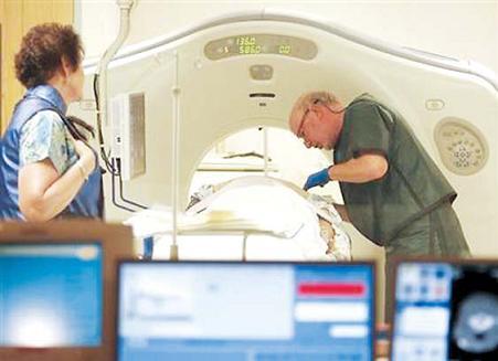 In this June 3, 2010 file photo, Dr. Steven Birnbaum works with a
patient in a CT scanner at Southern New Hampshire Medical
Center in Nashua, New Hampshire. New lung cancer screening
guidelines from three medical groups recommend annual scans
but only for an older group of current or former heavy smokers. (AP)