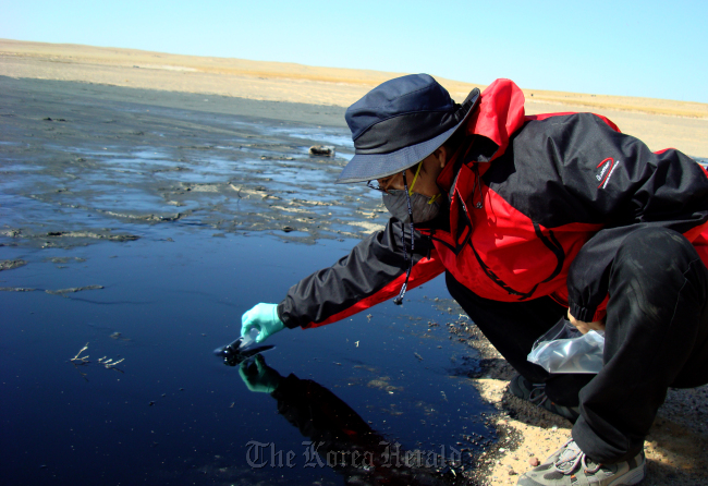 A mine researcher collects a water sample from mining areas in Mongolia. KOICA