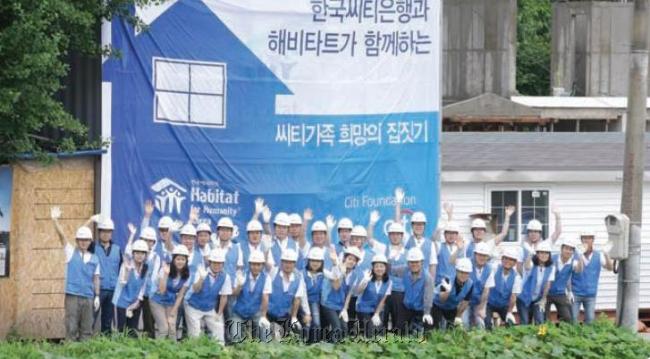 Citibank employees and members of Habitat for Humanity Korea pose during their voluntary work to build homes for the underprivileged.    Citibank