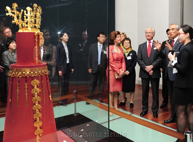 Sweden’s King Carl XVI Gustaf (third from right) and Queen Silvia (fourth from right) listen to Culture Minister Choe Kwang-shik (second from right) explain about a golden crown from the Silla Kingdom at the National Museum of Korea in Seoul on Tuesday evening. Culture Ministry