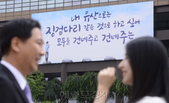 4일 오전 서울 광화문 교보생명 광화문글판 <여름편>에 시인 장석남의 '나의 유산은'에서 발췌한 시구가 걸렸다. 교보생명은 물질만능 시대에 배려와 소통이라는 삶의 소중한 가치를 되돌아보자는 뜻이 담겨 있다고 밝혔다. 박해묵 기자/mook@heraldm.com
4일 오전 서울 광화문 교보생명 광화문글판 <여름편>에 시인 장석남의 '나의 유산은'에서 발췌한 시구가 걸렸다. 교보생명은 물질만능 시대에 배려와 소통이라는 삶의 소중한 가치를 되돌아보자는 뜻이 담겨 있다고 밝혔다. 박해묵 기자/mook@heraldm.com
‘징검다리 같은 유산…부자들은 돈을 유산으로 준다는데…시인은 돌, 징검다리를 유산으로 하고 싶다고 노래한다.’ 4일 오전 서울 광화문 교보생명 광화문글판 여름편에 시인 장석남의 ‘나의 유산은’의 한 구절이 발췌됐다.  박해묵 기자/mook@heraldm.com