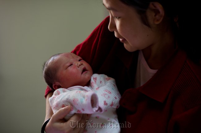 A Chinese mother holds her new born child in arms.  AFP