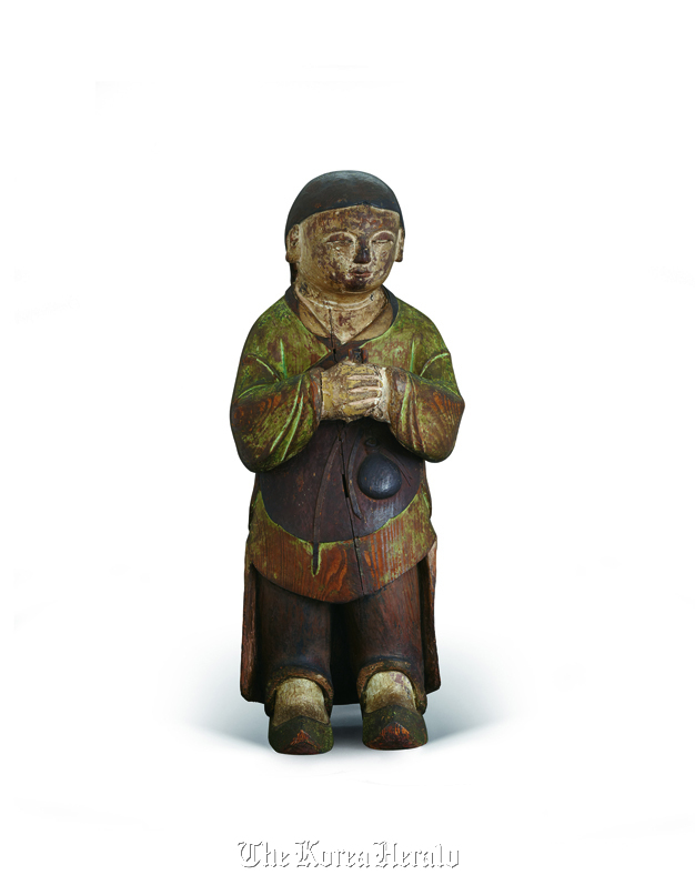 A wooden figure of a young boy from the late Joseon period. The piece is currently housed in the Honolulu Museum of Art.