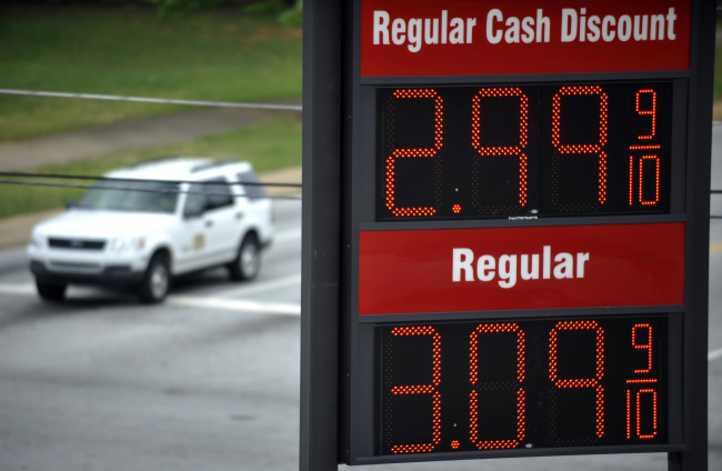 A sign for $2.99 a gallon gasoline is seen as vehicles wait for a traffic light to turn green at a Hot Spot convenience store on the corner of Henry and Converse Streets in Spartanburg, South Carolina.    (AP-Yonhap News)