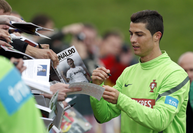 Cristiano Ronaldo signs autographs for fans at the end of a training session of Portugal at the Euro 2012 soccer championship in Opalenica, Poland, Tuesday.  (AP-Yonhap News)