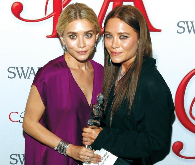 Ashley Olsen (left) and Mary Kate Olsen, designers of The Row, pose backstage after winning Womenswear Designer of the Year at the CFDA Fashion Awards on Monday in New York. (AP-Yonhap News)