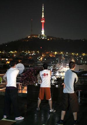 Kim stretches after a night session with his boxing students under the Namsam Tower.  Yonhap News