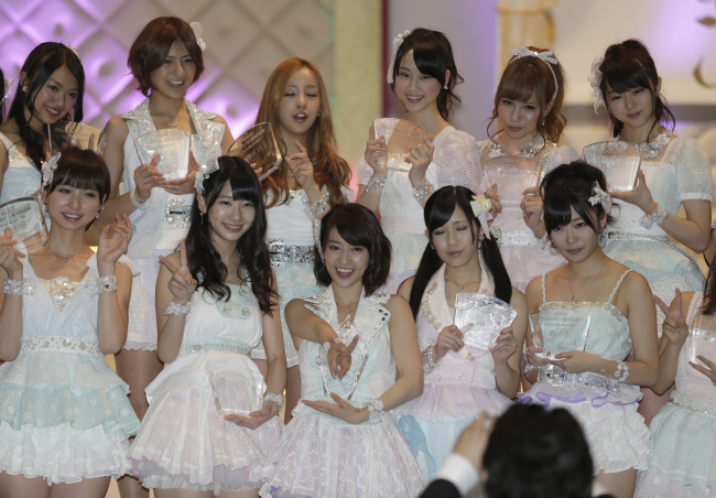 Japan’s all-girl pop idol group AKB48 member Yuko Oshima (front row center) flashes a victory sign, as she poses with other members after winning the annual AKB48 popularity poll in Tokyo Wednesday.  AP-Yonhap News