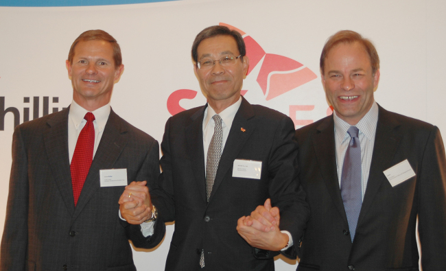 SK E&S CEO Moon Duk-kyu (center) poses with ConocoPhillips Australia president Todd Creeger (left) and Santos CEO David Knox after signing a contract in Kuala Lumpur, on Thursday.   (SK Group)