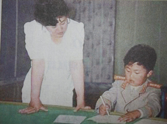 This image captured from a video obtained by Japan’s Mainichi Shimbun shows North Korea’s young leader Kim Jong-un (right) in his childhood and his late mother Ko Young-hui in the 1980s or 90s.    Yonhap News