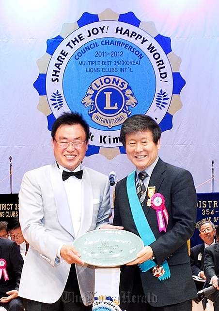 Home Plus CEO and chairman Lee Seung-han (right) receives the Korea Lions Grand Prize on Saturday from Kim Tae-ok, governor of 354-C District of the Korea State Council of the Lions Clubs International, in central Seoul. The prize is given by the volunteer organization to an individual who greatly contributed to spreading the volunteering and sharing spirit.  Home Plus
